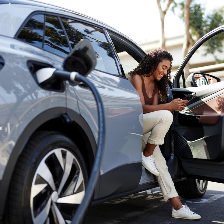 Driver relaxing in her car while it charges